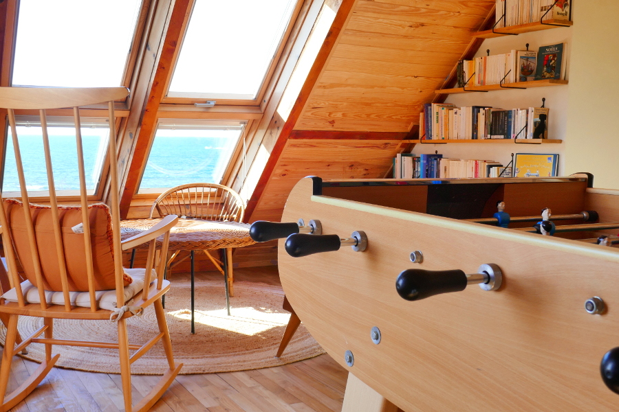 Baby-foot et salon avec vue sur la mer dans la salle de jeu du gîte Ti Bili à Plouhinec dans le sud de la Bretagne