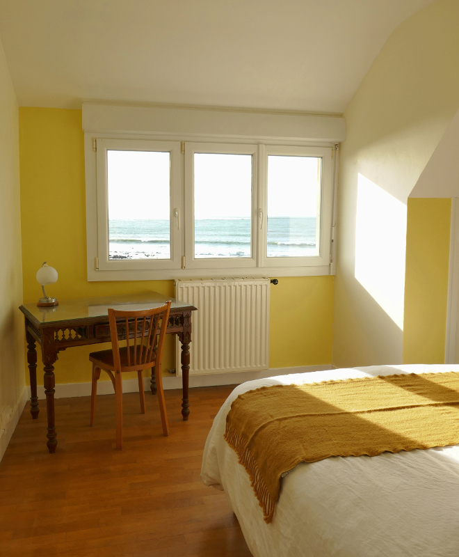 Chambre avec vue sur la mer, lit double et bureau dans la maison de vacances Ti Bili en Bretagne