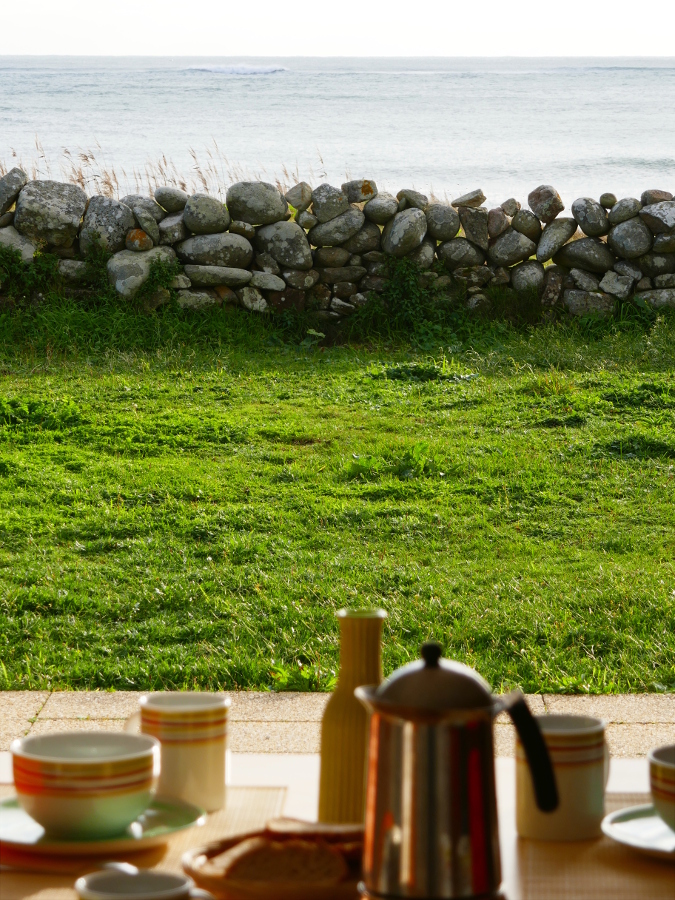 Petit-déjeuner face à l'océan sur la terrasse de la maison de vacances Ti Bili au bord de l'eau à Plouhinec en Bretagne