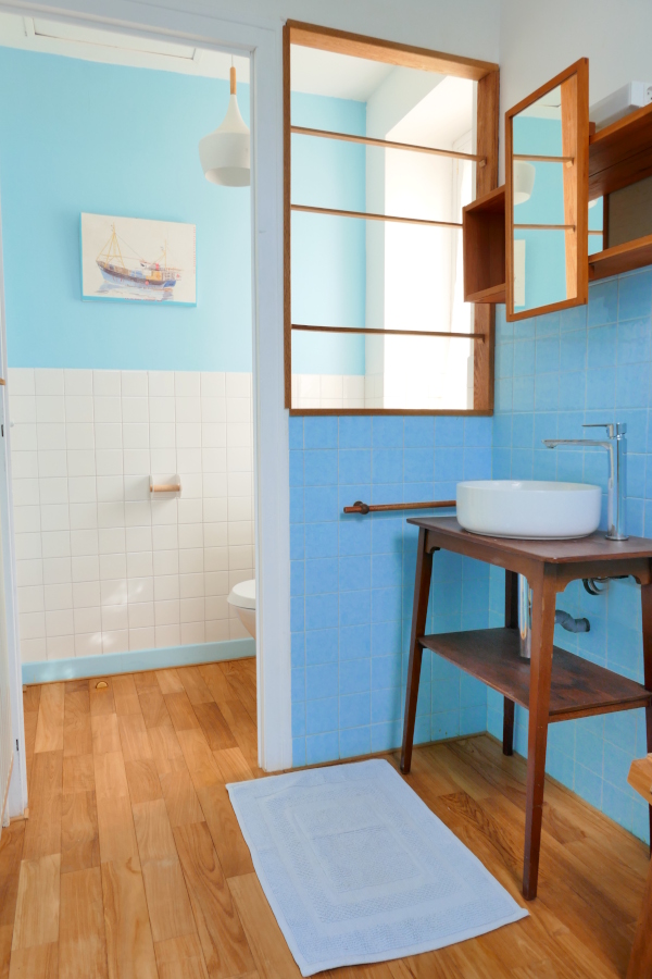 Salle de bain parquet en bois et toilettes dans le gîte vacances Ti Bili à Plouhinec dans le Finistère sud