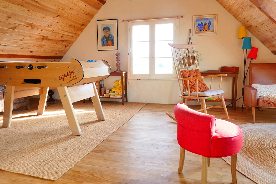 La salle de jeu avec authentique parquet en bois, baby-foot et salon du gîte Ti Bili à Plouhinec en Bretagne