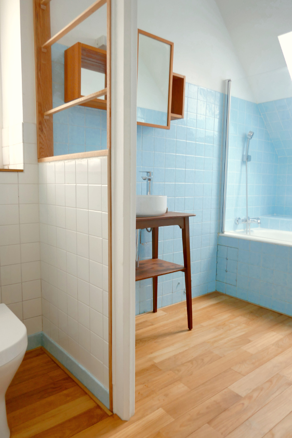 Salle de bain avec parquet en bois et baignoire dans la maison de vacances Ti Bili en Bretagne