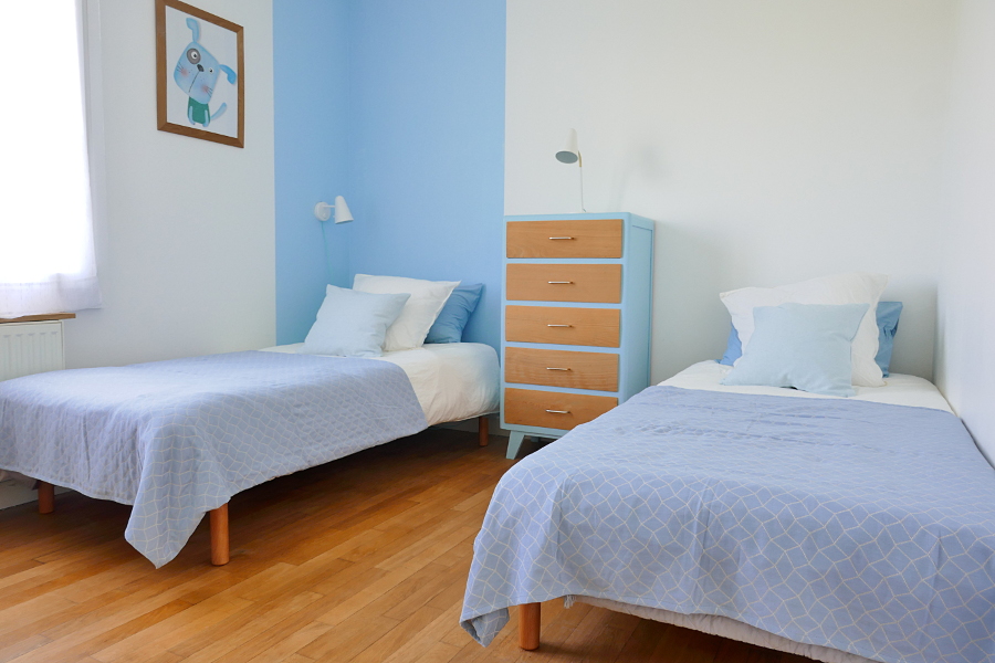 Chambre d'enfants avec lits simples et commode dans la maison de vacances Ti Bili en Bretagne